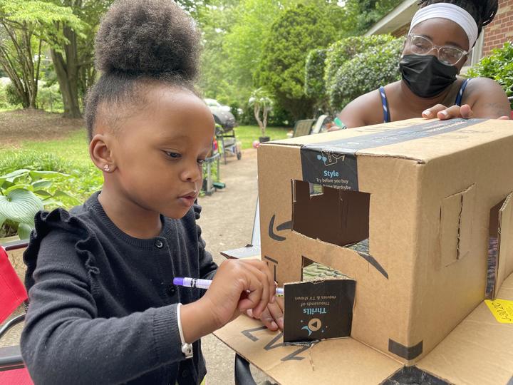 Child drawing on a box