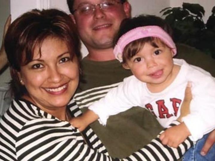 Mother and father smile with DHH baby