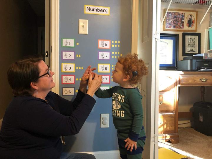 Child with cochlear implant learning ASL
