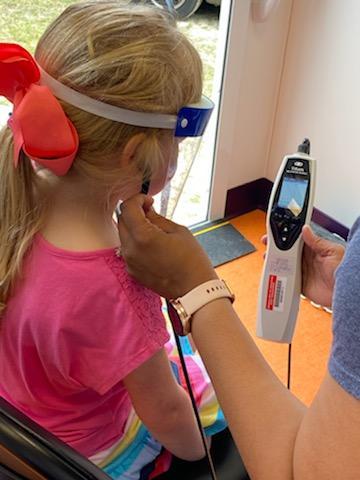 A young girl getting her hearing tested.