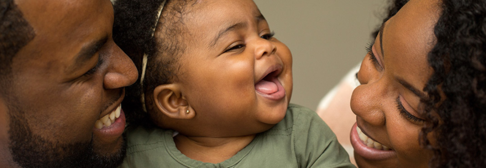 Smiling baby with two smiling adults