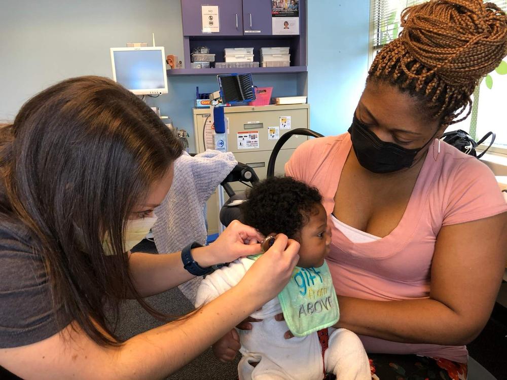 baby in a clinical office having hearing aids fitted