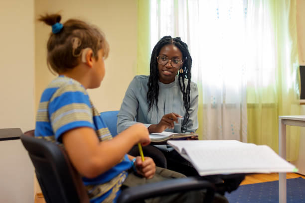 A teacher speaking with a student wearing hearing aid