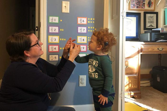 Child with cochlear implant learning ASL